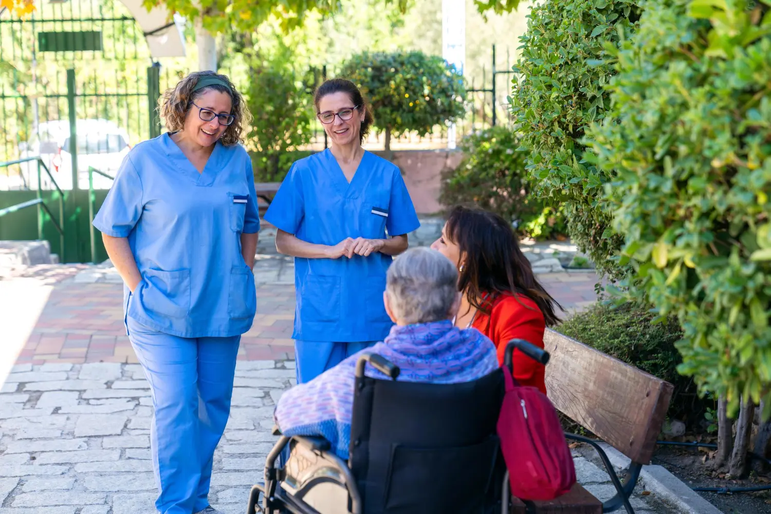 Caregiver gently holding the hand of an elderly patient at home